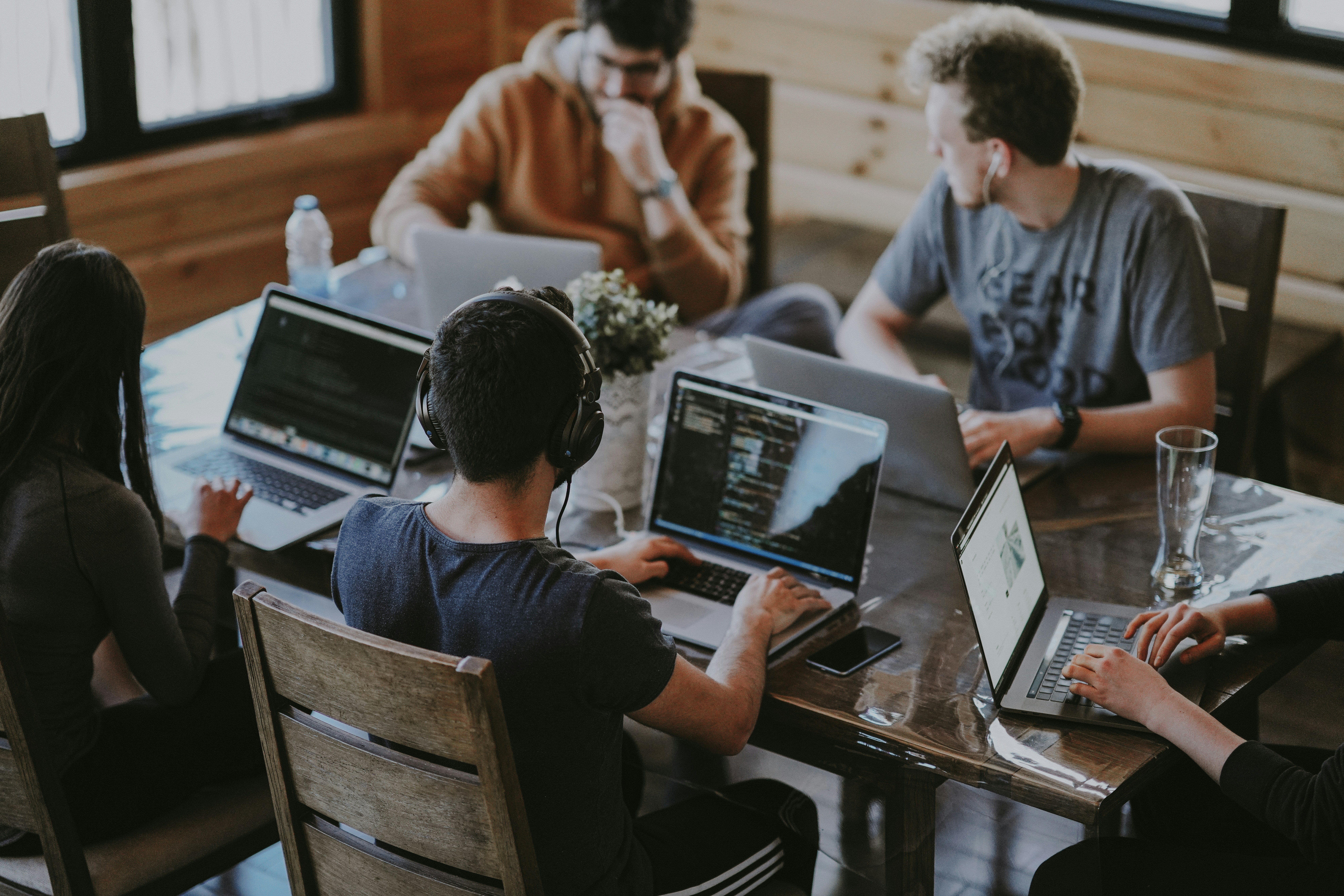 A group of people sitting around a table working on a project together